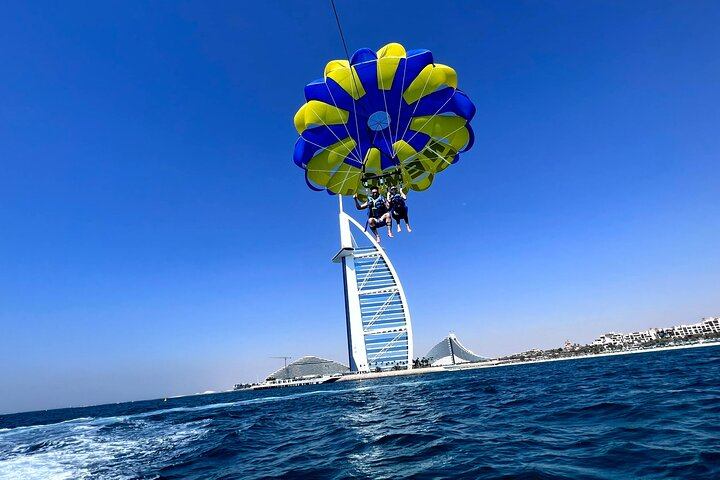 Soar high above the azure waters taking in breathtaking views of the iconic Burj Al Arab while enjoying an exhilarating parasailing experience that blends adventure with stunning scenery.